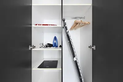 a white door with a ladder next to a sink at Spacious 1-Bedroom Apartment in JLT in Dubai