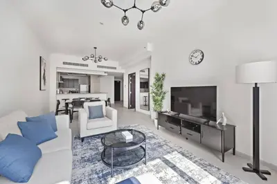 a living room with a white couch and a tv at Spacious 1-Bedroom Apartment in JLT in Dubai