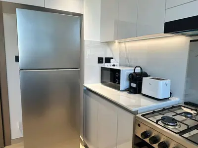 a kitchen with a refrigerator and a microwave at Stylish 1br Jvc Spacious Layout Pool View in Dubai