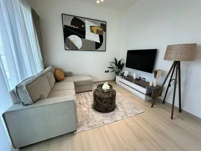 a living room with a couch and a flat screen tv at Stylish 1br Jvc Spacious Layout Pool View in Dubai
