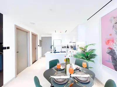 a dining room with a table and chairs and a kitchen at City Views & Comforts at Binghatti Corner in Dubai