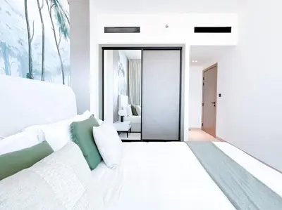 a white bedroom with a white bed and a living room at City Views & Comforts at Binghatti Corner in Dubai