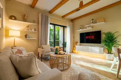 a living room with a couch and a tv at Boho Nordic Bliss in Dubai in Dubai