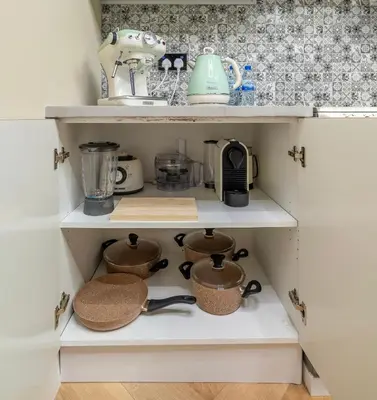 a cupboard filled with pots and pans at Boho Nordic Bliss in Dubai in Dubai