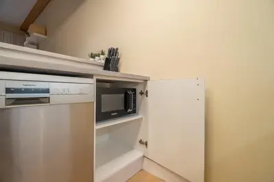 a small kitchen with a microwave and a refrigerator at Boho Nordic Bliss in Dubai in Dubai