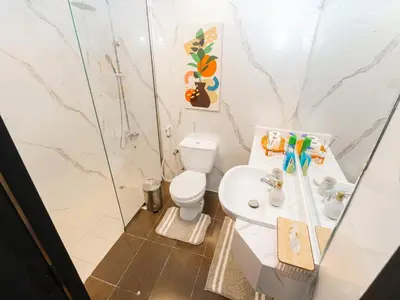 a bathroom with a toilet and a sink at Serene 1BR in Diamond Views 3 JVC - Pool Access & Peaceful Living , Managed by Think Realty in Dubai