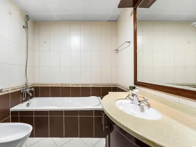 a bathroom with a tub and a sink and a mirror at Spacious Home Near Metro & Beach in Dubai Marina in Dubai