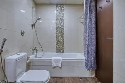 a bathroom with a toilet and a tub and a sink at ShoresInn - Aesthetic Stay with Dubai Marina View in Dubai