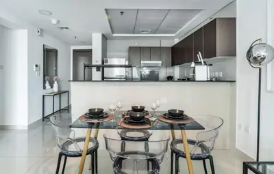 a dining room with a glass table and chairs at ShoresInn - Aesthetic Stay with Dubai Marina View in Dubai