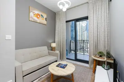 a living room with a couch and a large window at Stylish and Versatile for Business or Leisure in Dubai