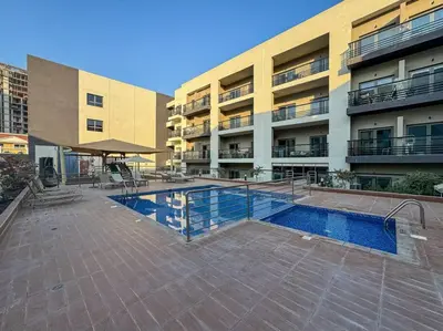 a swimming pool in front of a building at Serene Studio APT with Pool and Gym in Dubai