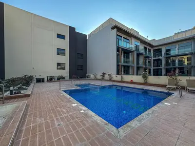 a swimming pool in front of a building at Serene Studio APT with Pool and Gym in Dubai