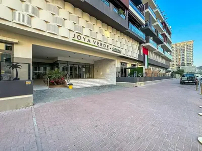 a large building with a parking lot in front of it at Serene Studio APT with Pool and Gym in Dubai