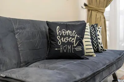 a gray couch with black and white pillows on it at 2-Bedroom Marina Skyline View in JLT in Dubai