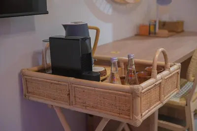 a wicker basket with a television and bottles on a table at UrbanHomes - Cozy, Wooden and Travel Eco-Friendly Studio in Dubai