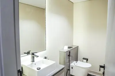 a white bathroom with a sink and a mirror at Stylish & Cozy Apartment Awaits You in Dubai