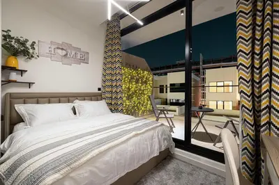 a bedroom with a bed and a large window at UrbanHomes - Cozy Spacious Exceptional Studio in Heart of Dubai at JVC in Dubai