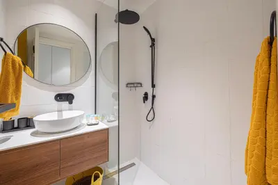 a bathroom with a sink and a shower with a mirror at UrbanHomes - Cozy Spacious Exceptional Studio in Heart of Dubai at JVC in Dubai