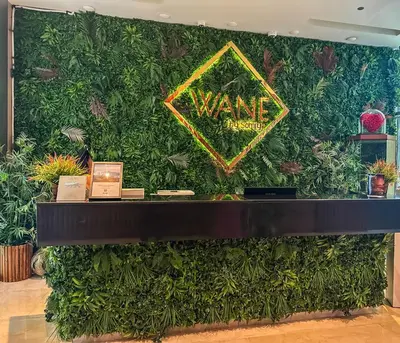 a wall covered in green plants with a sign on it at Luxury Apartments - Stunning Marina View - 5-Star Hotel Amenities in Dubai