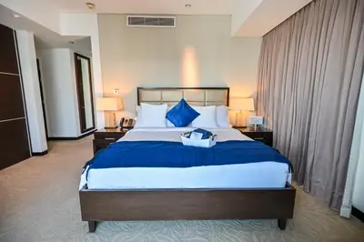 a hotel room with a large bed with blue pillows at Luxury Apartments - Stunning Marina View - 5-Star Hotel Amenities in Dubai