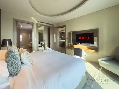 a bedroom with a bed with a tv on the wall at Spacious & Cozy 1BR - Stunning City View in Dubai