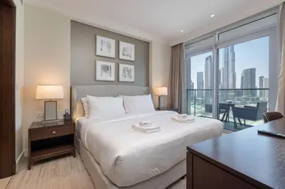 a bedroom with a large white bed and a large window at Luxury Living - Spectacular Burj Khalifa Views in Dubai