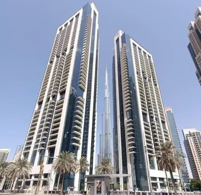 two tall buildings with palm trees in front of them at Chic 1BR Retreat , Blvd Views, Walk to Dubai Mall in Dubai