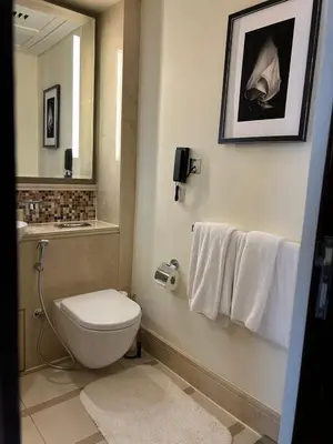 a bathroom with a toilet and a sink and towels at The Address Downtown Studio 1911 in Dubai