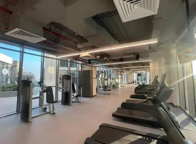 a gym with a row of treadmills and elliptical machines at Appealing 3BR at 17 Icon Bay Dubai Creek Harbour by Deluxe Holiday Homes in Dubai