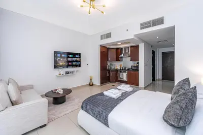 a bedroom with a white bed and a couch at Downtown Studio with Balcony at 29Blvd in Dubai