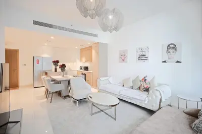 a living room with a white couch and a table at Emaar Beachfront Luxe Retreat in Dubai