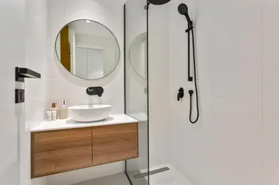 a bathroom with a shower with a sink and a mirror at Sleek Brand New Studio in Loci Residence JVC in Dubai