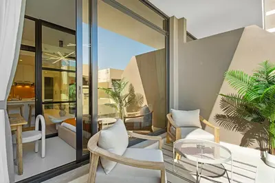 a balcony with chairs and a table and some plants at Sleek Brand New Studio in Loci Residence JVC in Dubai