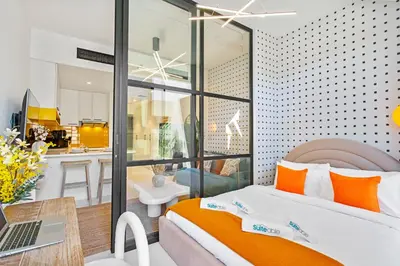 a bedroom with a bed and a laptop on a table at Sleek Brand New Studio in Loci Residence JVC in Dubai