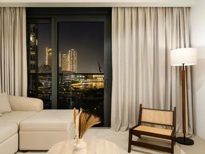 a living room with a white couch and a large window at UrbanStays Dubai - Act Tower in Dubai