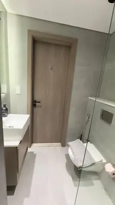 a bathroom with a toilet and a wooden door at New! Modern cosy Studio Laya Heights in Dubai
