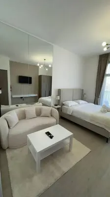 a living room with two beds and a couch and a table at New! Modern cosy Studio Laya Heights in Dubai