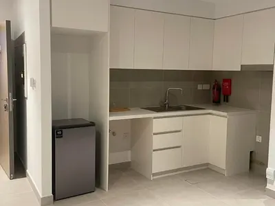 a kitchen with white cabinets and a sink and a refrigerator at 'Dubai Creek Horizon Tower2' 1-Bedroom in Dubai