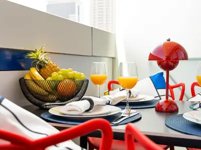 a table with two glasses of wine and a bowl of fruit at Modern High-Floor Apartment with Burj Khalifa View by Dejaview Stays in Dubai