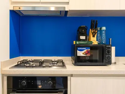 a kitchen with a stove and a microwave at Modern High-Floor Apartment with Burj Khalifa View by Dejaview Stays in Dubai