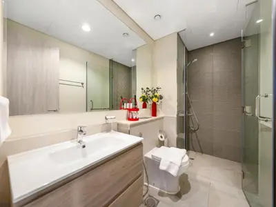 a bathroom with a sink and a toilet and a shower at Modern High-Floor Apartment with Burj Khalifa View by Dejaview Stays in Dubai