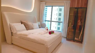 a bedroom with a white bed with a flower on it at USMANS 3 Bedroom Apartment all Rooms Sea View Direct Beach Access Daily HOUSEKEEPING JBR in Dubai