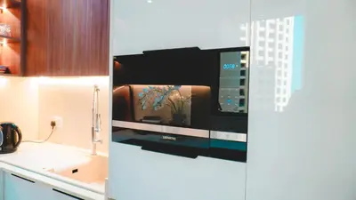 a kitchen with a tv on a wall at USMANS 3 Bedroom Apartment all Rooms Sea View Direct Beach Access Daily HOUSEKEEPING JBR in Dubai