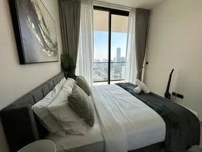 a bedroom with a large bed with a large window at Elegant 1br Escape Jvc Pool & Balcony Access in Dubai