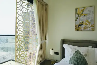 a bedroom with a bed and a window with a view at Modern Luxury Fully Furnished 1BH Apartment in Binghatt Emerald JVC - Easy Access to JBR, Circle Mall & Dubai Hills Mall in Dubai