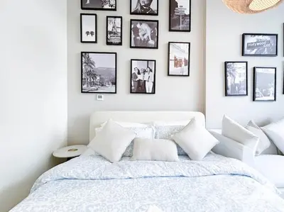 a bedroom with a white bed with pictures on the wall at Meydan Bliss Luxurious Studio with Private Balcony in Dubai