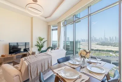 a living room with a table and a large window at Manzil - 1BR Apartment in Farhad Aziz Residence with Burj View in Dubai