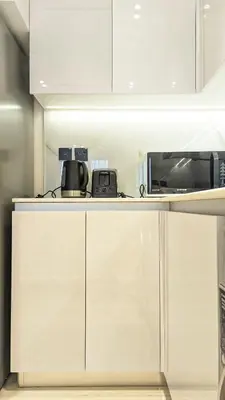 a kitchen with white cabinets and a microwave at Modern Luxury Fully Furnished 1BH Apartment in Binghatt Heights JVC - Easy Access to JBR, Circle Mall & Dubai Hills Mall in Dubai