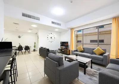 a living room with couches and a clock on the wall at 2 min walk to JBR Beach & Dubai Marina - Sea View in Dubai