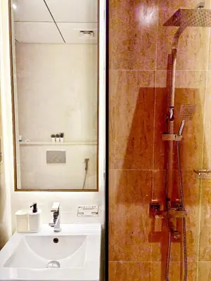 a bathroom with a sink and a shower with a mirror at Cozy Studio JVC Dubai, Short Drive to Dubai Marina, JBR, Downtown Dubai in Dubai